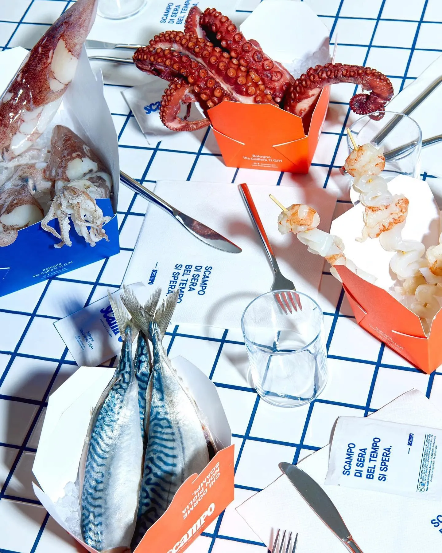 Pesce crudo nelle vaschette Scampo arancioni e blu — sgombro, polpo, calamari e spiedini di gamberi.